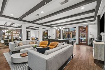 A modern clubroom with a grey sofa and a coffee table.